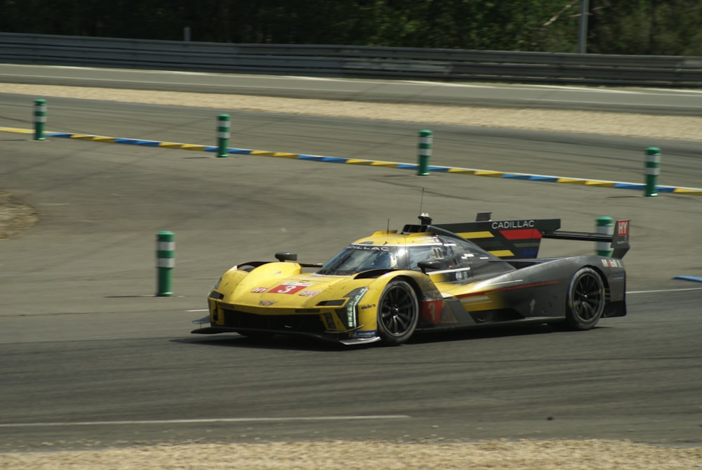 a yellow race car driving on a race track