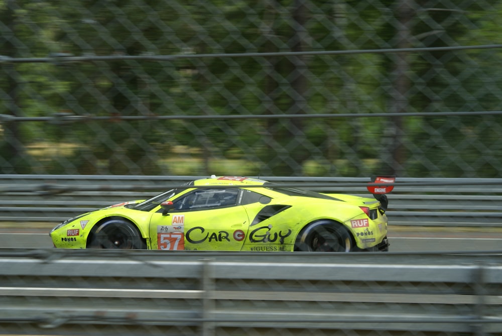 a yellow sports car driving on a track