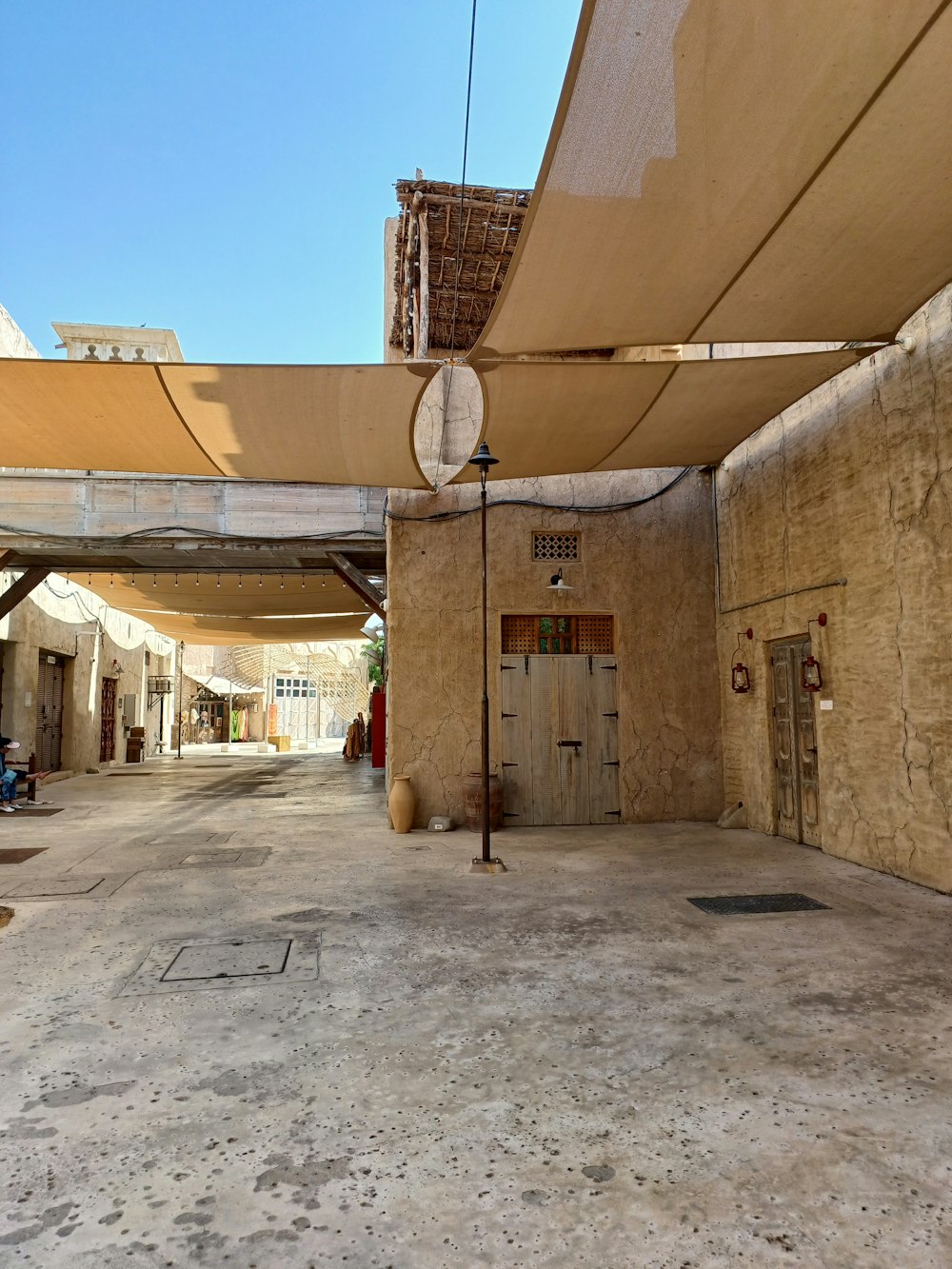 an empty street with a clock on the side of it