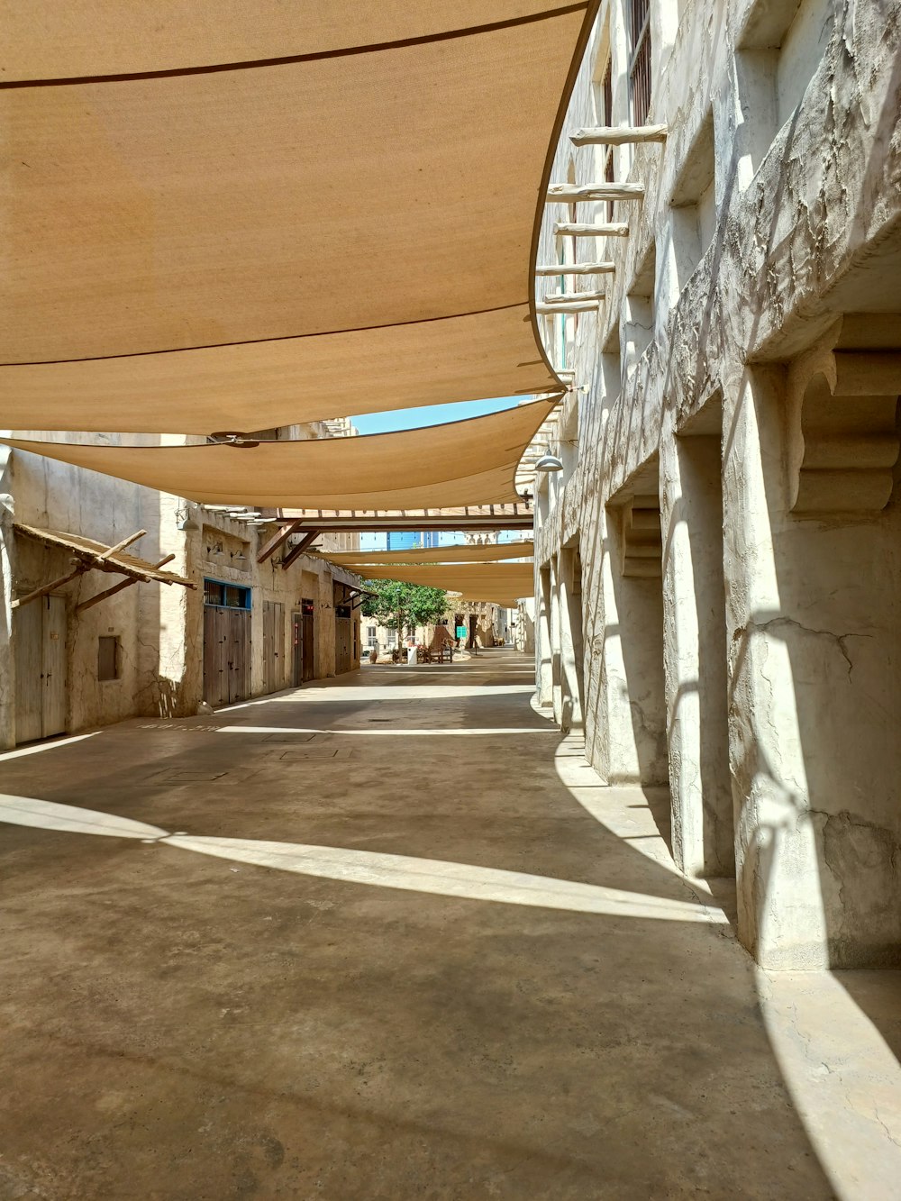a street lined with buildings and covered in shade