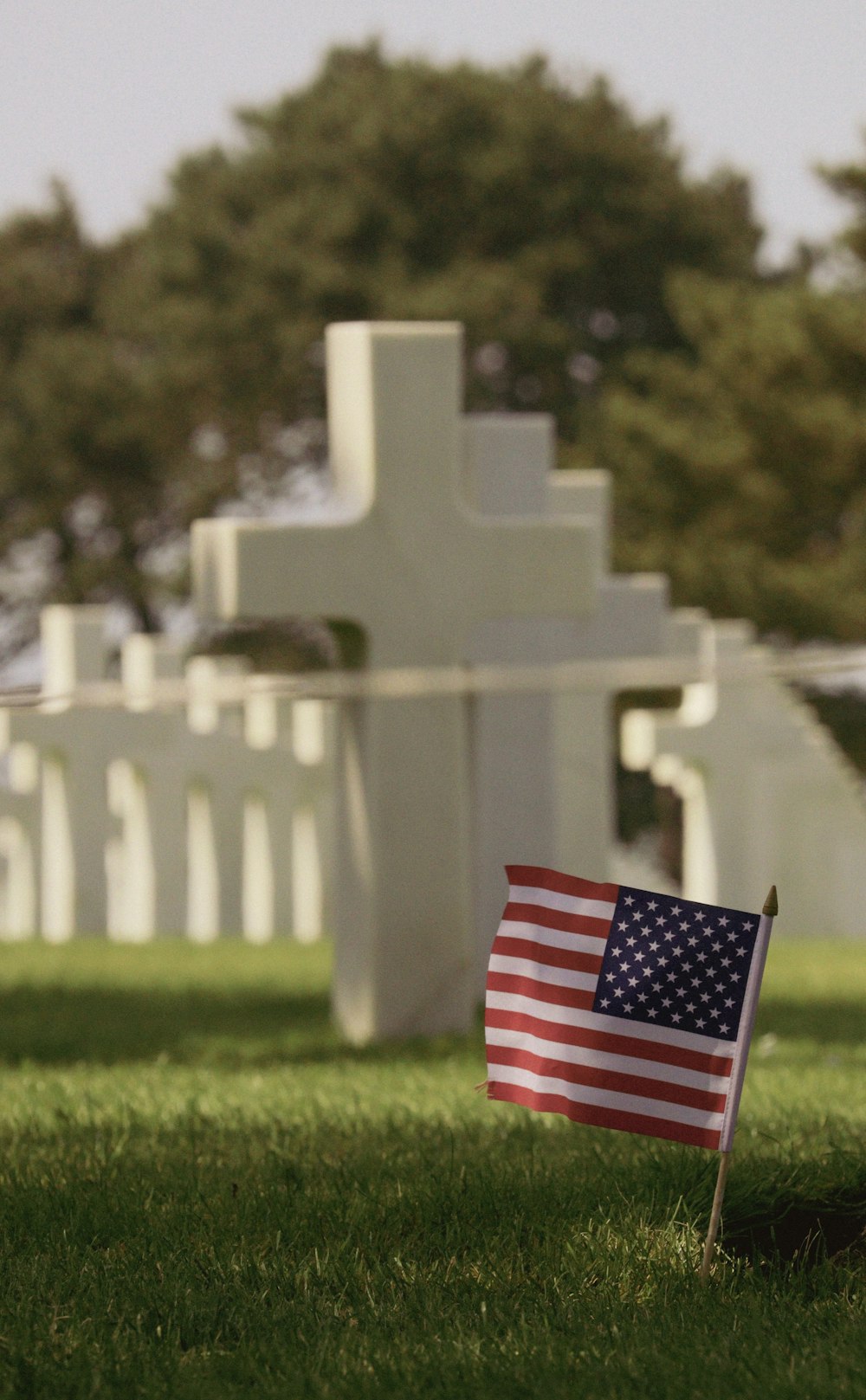 a flag laying in the grass in front of a cross