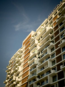 A modern apartment building with clean lines and balconies, bathed in warm sunlight.