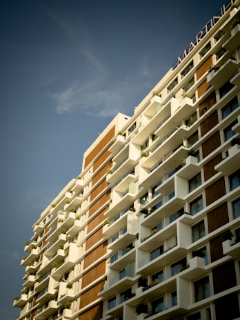 A bright, modern Moroccan apartment building with balconies and clear blue sky.