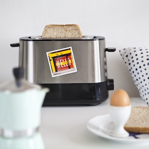 A vintage toaster popping up golden-brown slices beside a fresh jar of jam.