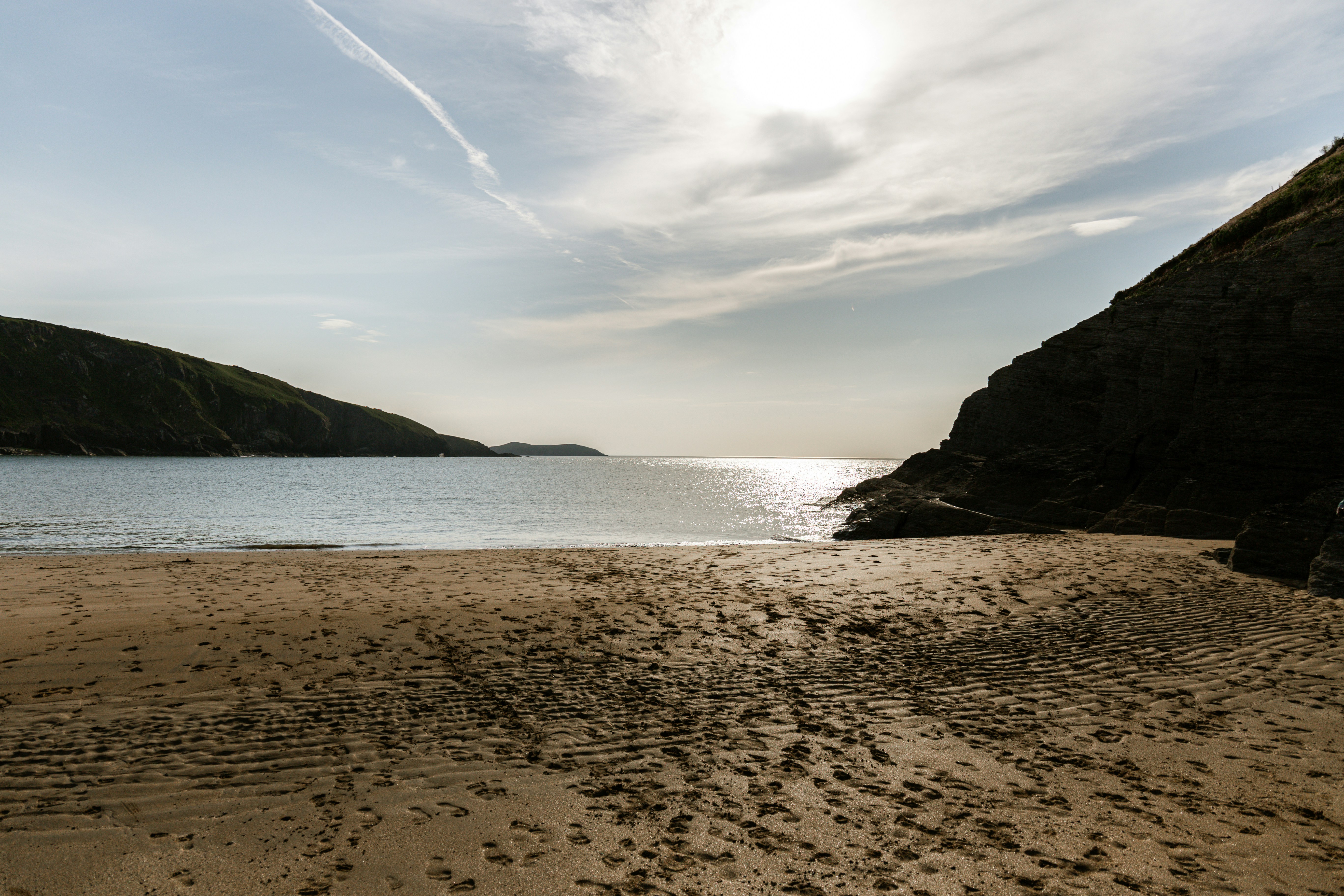 a sandy beach next to a body of water