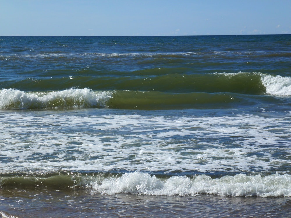 a couple of small waves coming in to the shore