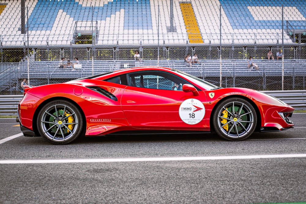 a red sports car driving down a race track