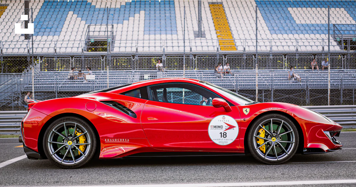 Foto zum Thema Ein roter sportwagen, der eine rennstrecke hinunterfährt ...