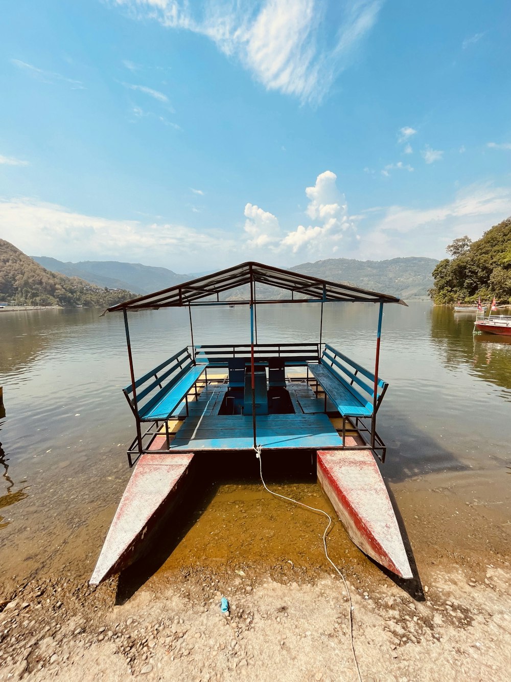 a boat sitting on top of a lake next to a shore