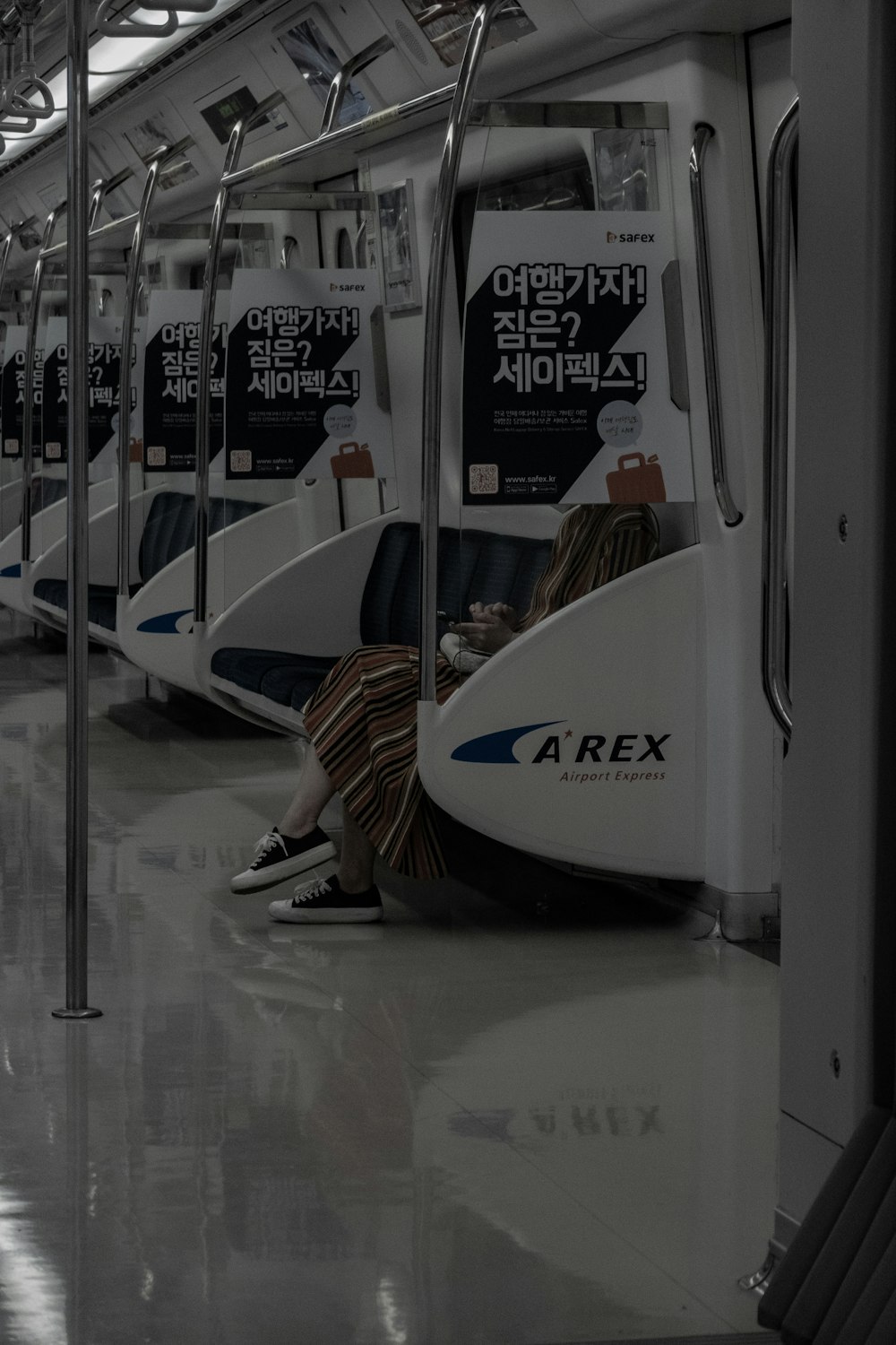 a person sitting on a train with their feet on the ground