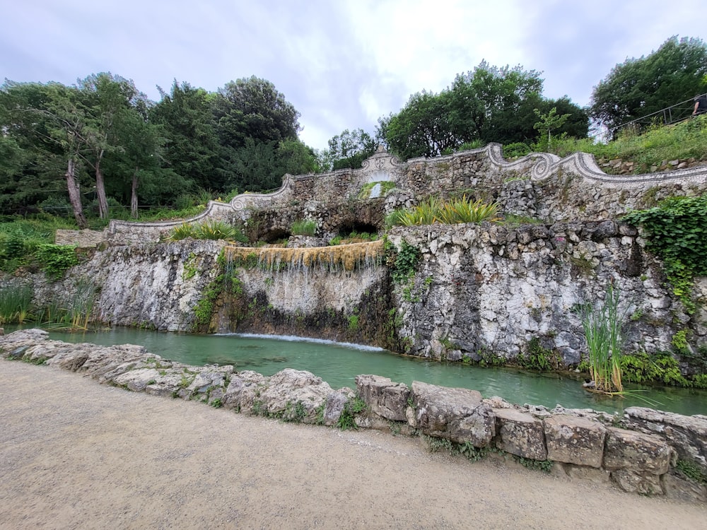 a stone wall with a waterfall in the middle of it