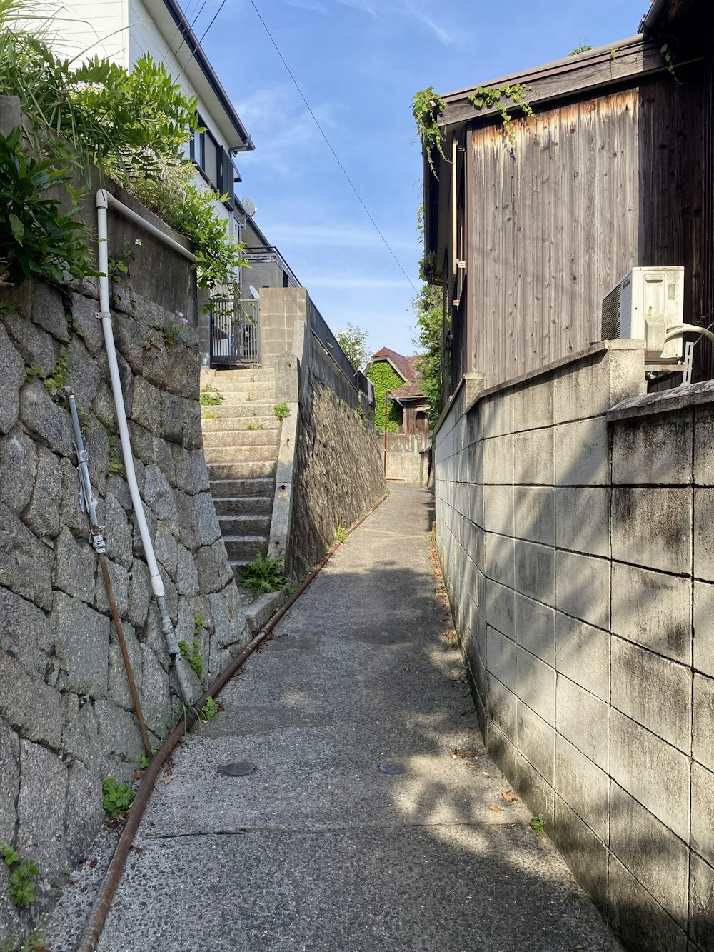 une ruelle étroite avec un mur de pierre et une échelle