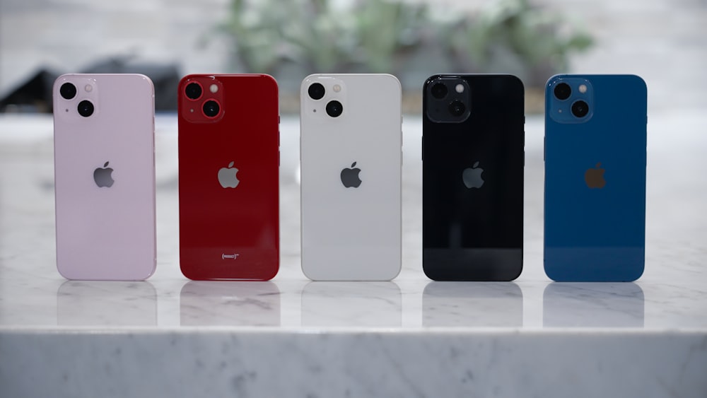 four different colored iphones sitting on a table