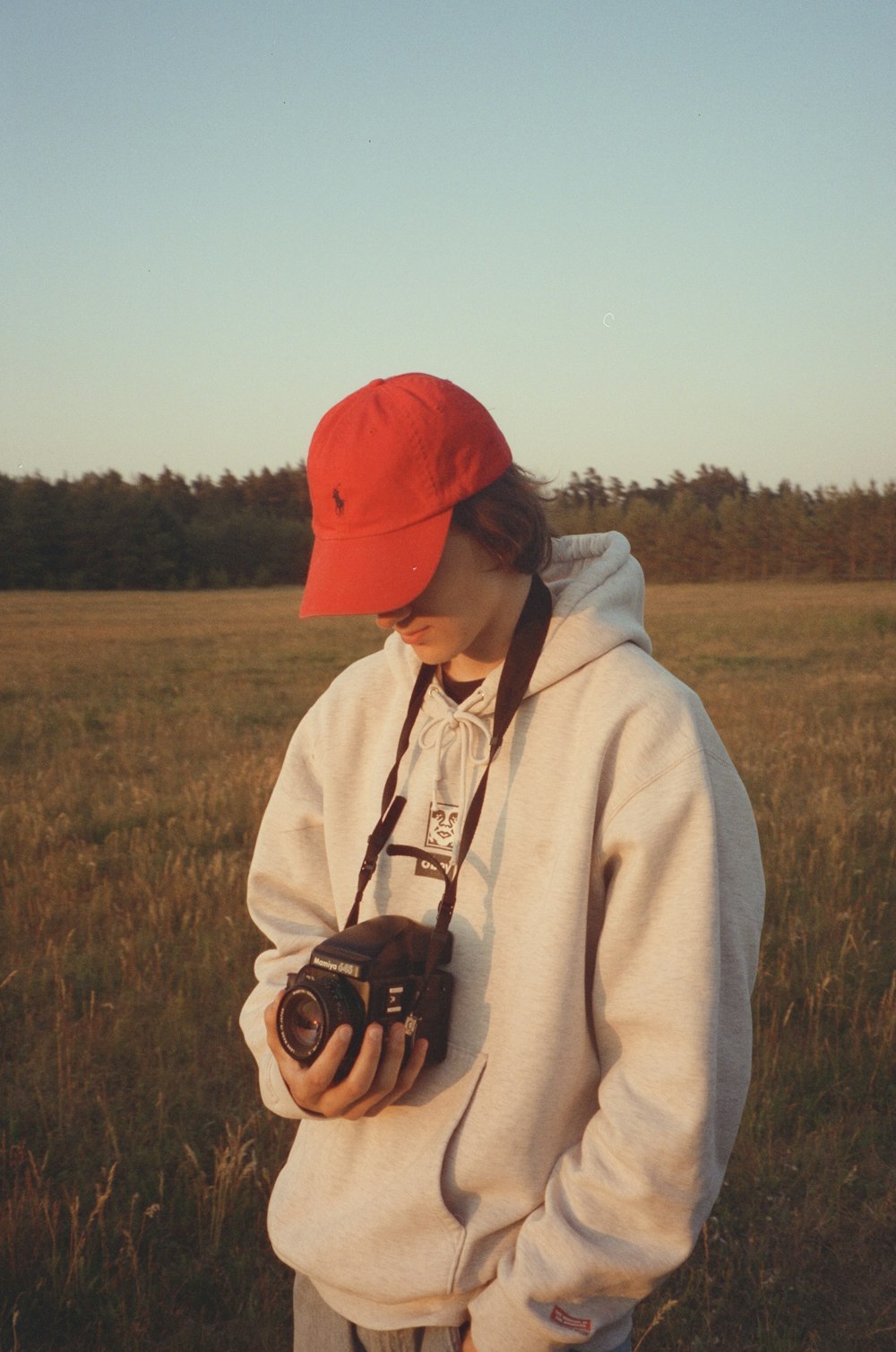 a person standing in a field with a camera