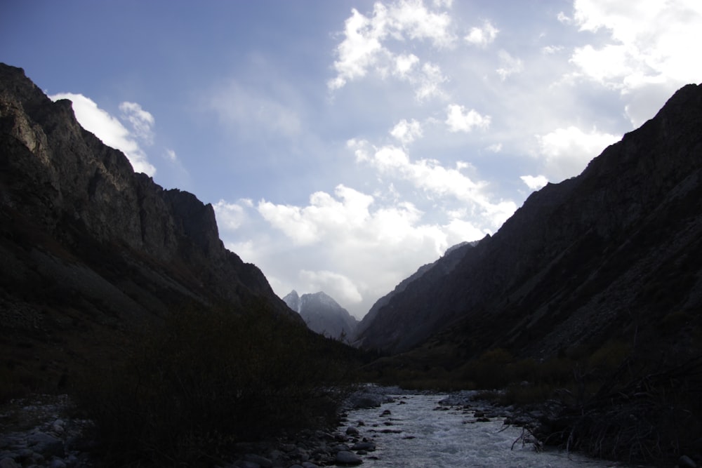 a river running through a valley surrounded by mountains