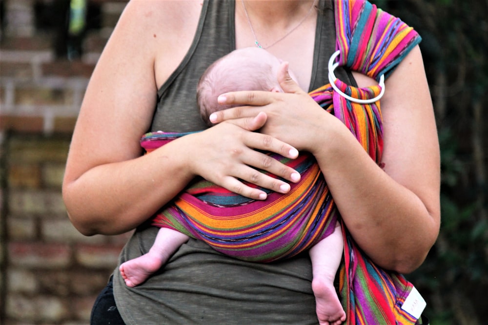 a woman holding a baby in a sling