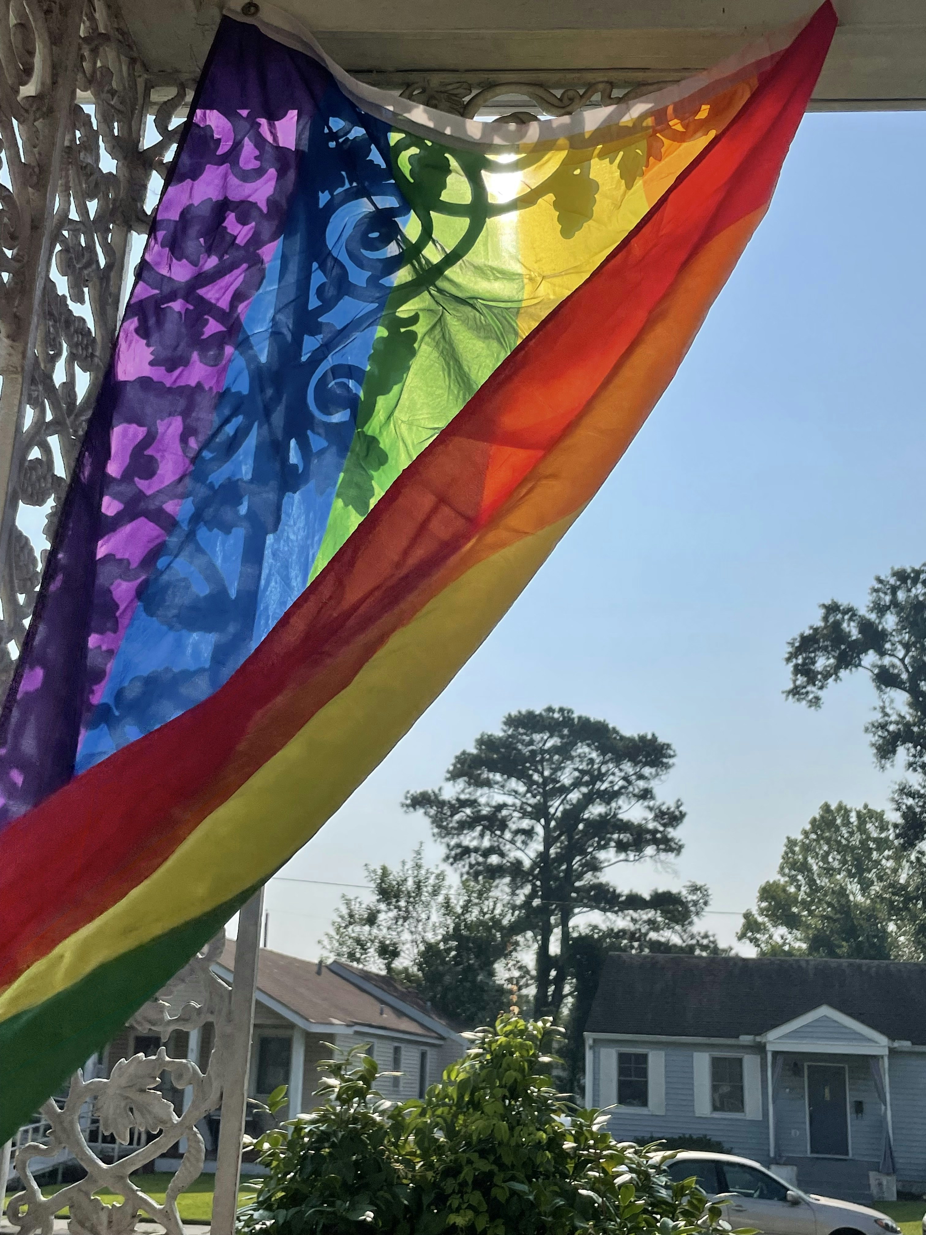 A rainbow flag hanging from the side of a house photo – Free Car Image ...