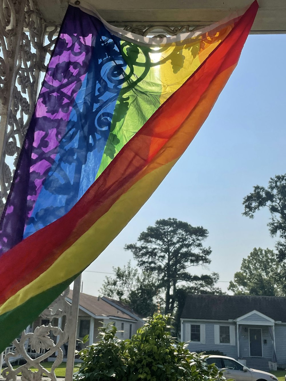 a rainbow flag hanging from the side of a house