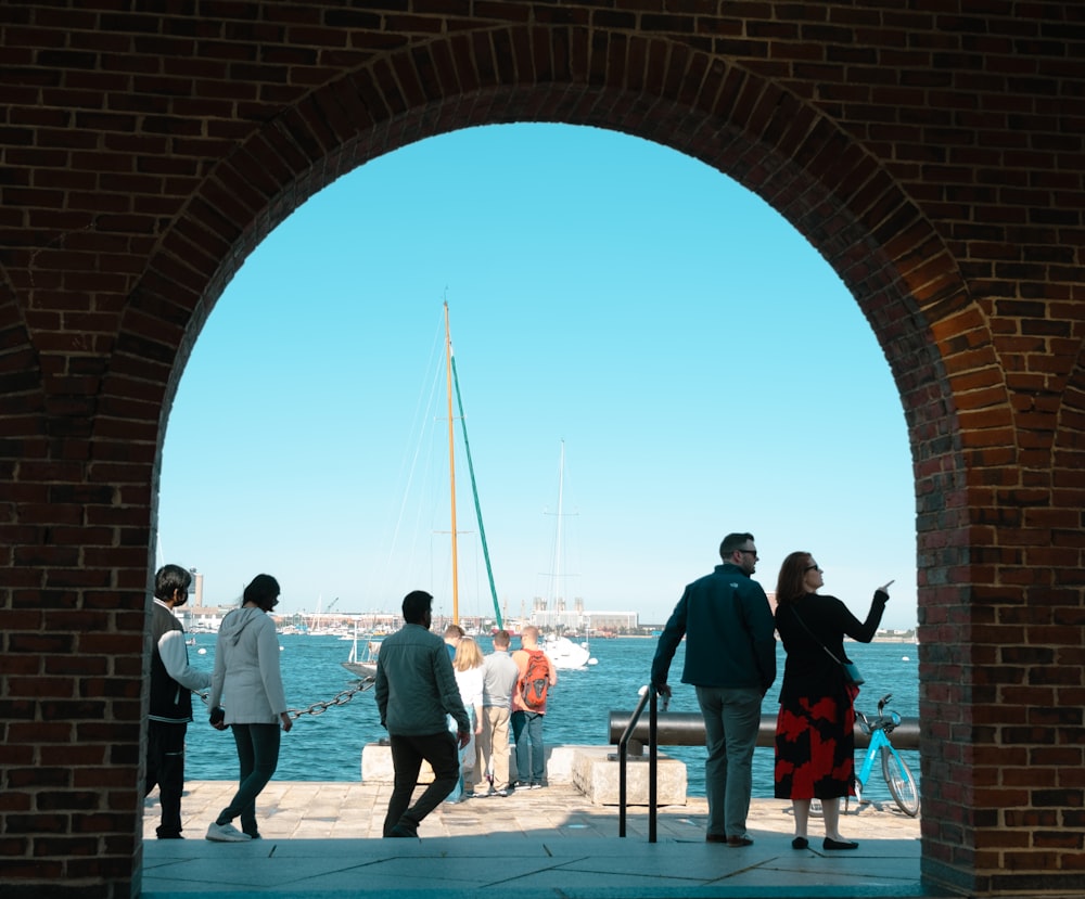 a group of people standing next to each other near a body of water