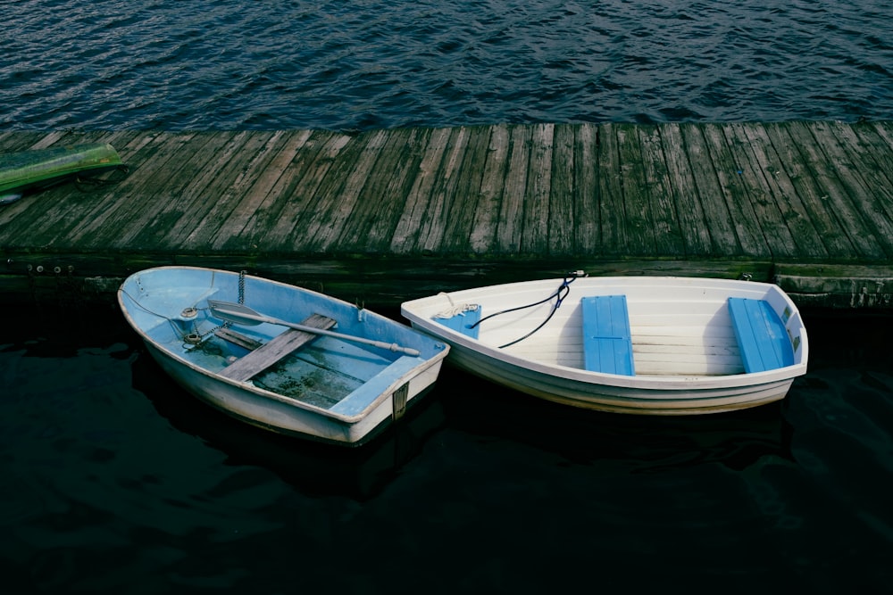 two small boats tied to a wooden dock