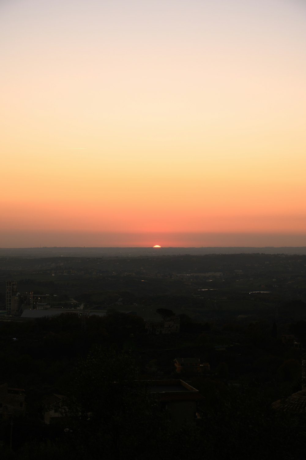 the sun is setting over the horizon of a city