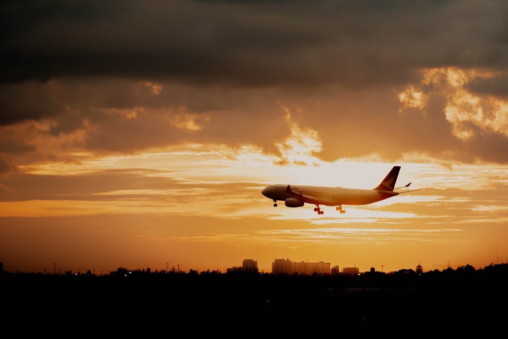 a plane is flying in the sky at sunset