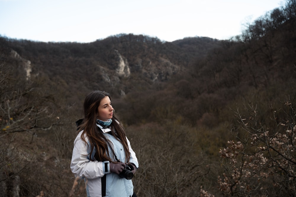 a woman standing in front of a mountain