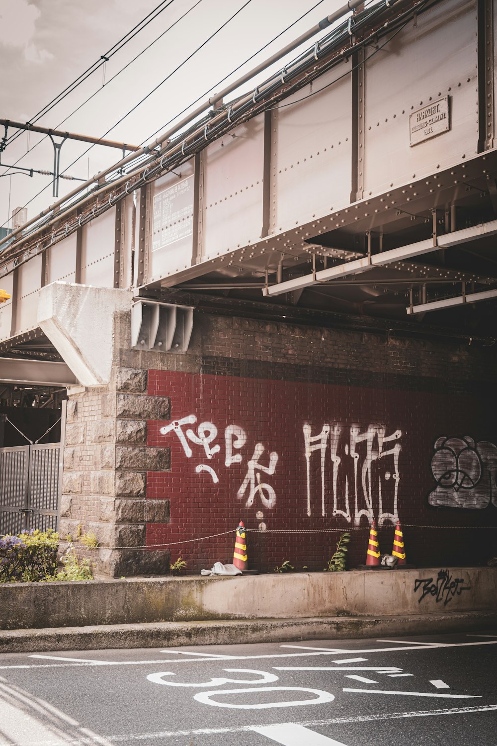 graffiti on the side of a building under a bridge