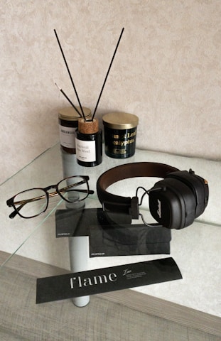 A cozy arrangement of scented candles, scrunchies, and eye masks on a rustic wooden table.