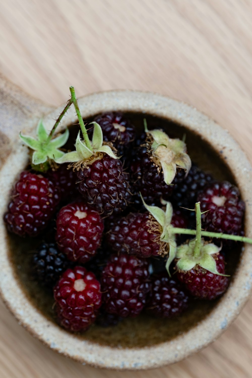 a bowl filled with berries on top of a wooden table