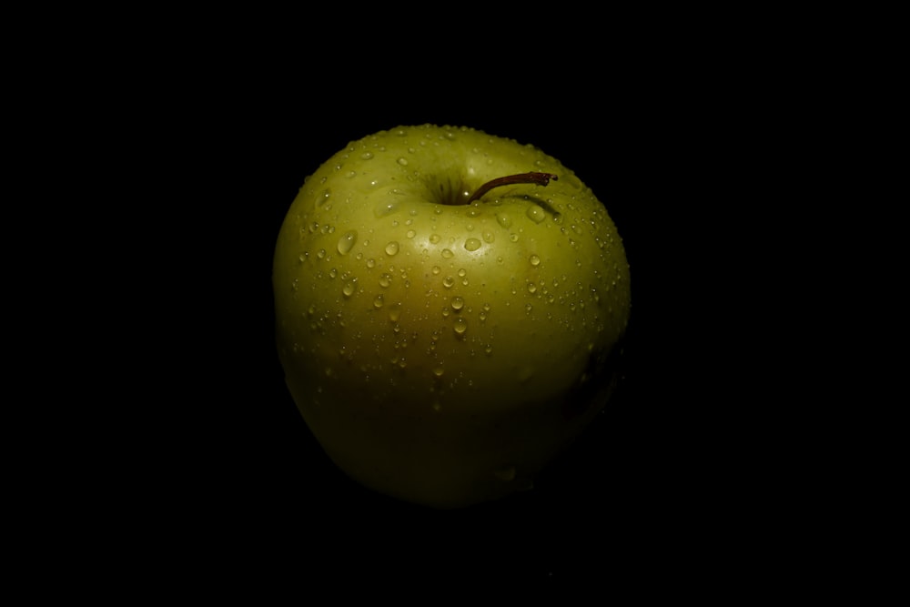 a green apple with water droplets on it