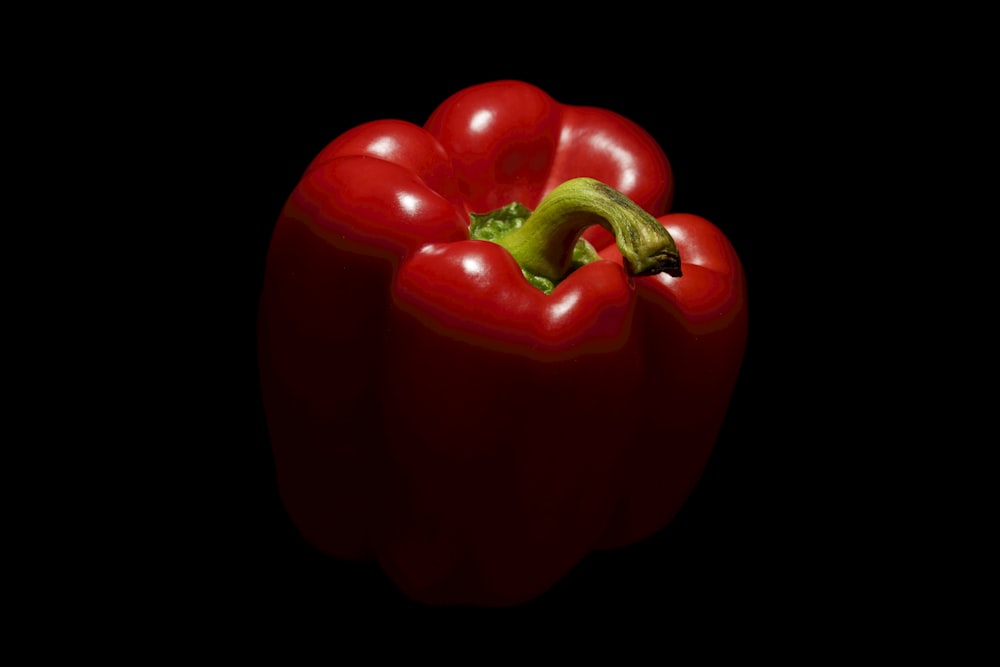 a red bell pepper on a black background