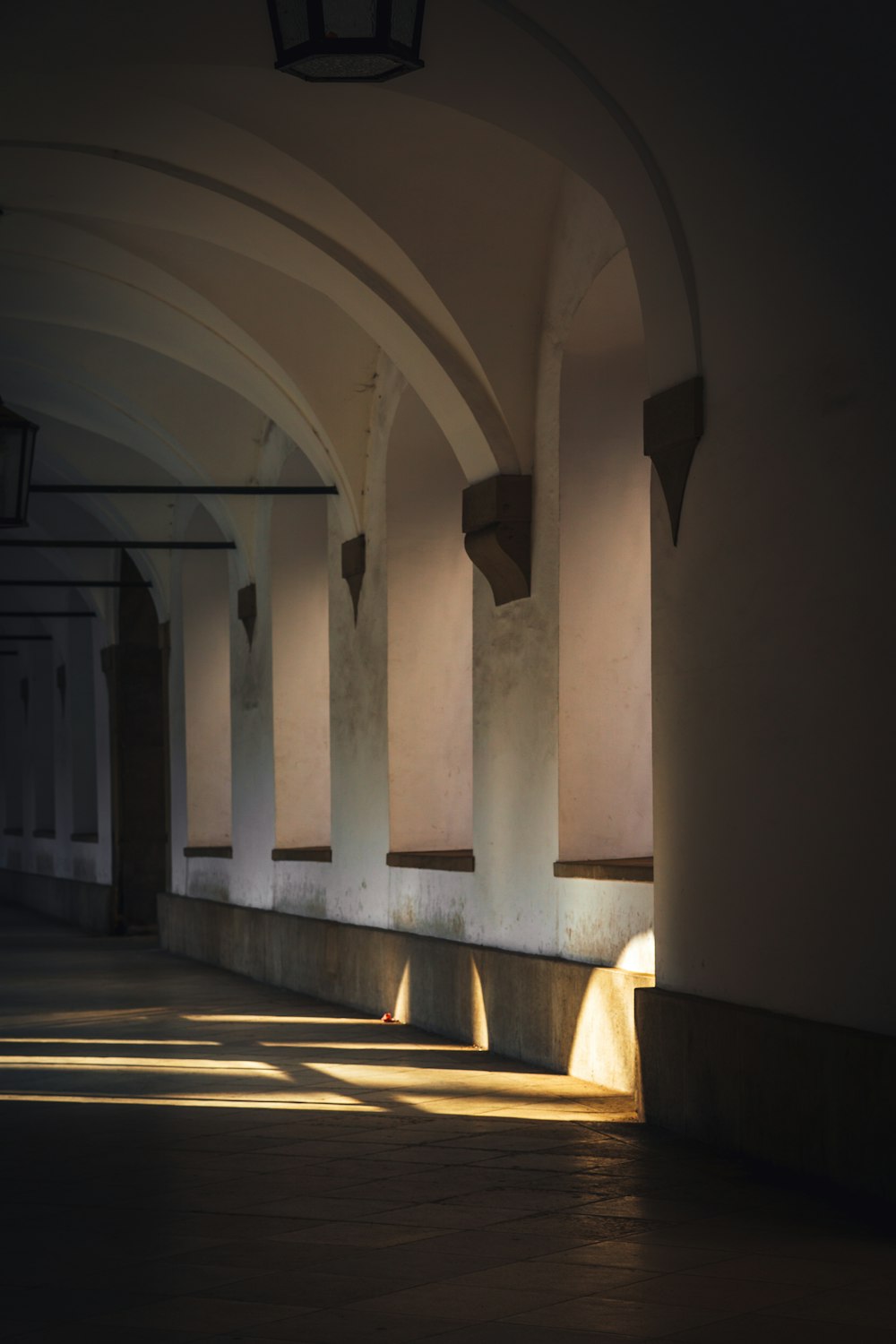 a long hallway with a light shining on the floor