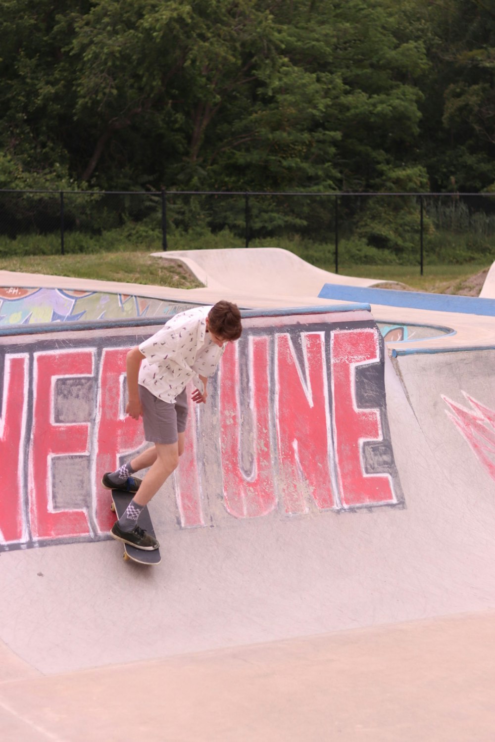 um homem andando de skate na lateral de uma rampa