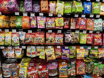 A colorful assortment of snacks and everyday essentials on store shelves.