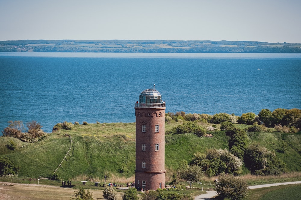 a lighthouse on a hill overlooking a large body of water