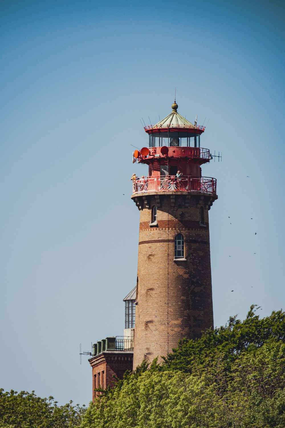 a red and white light house on top of a hill