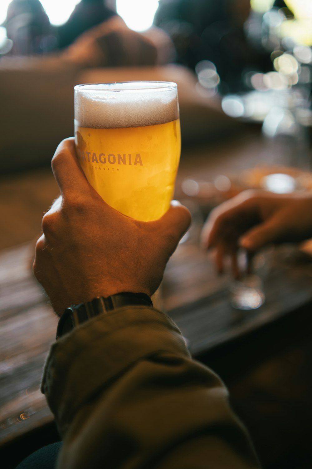 a person is holding a glass of beer