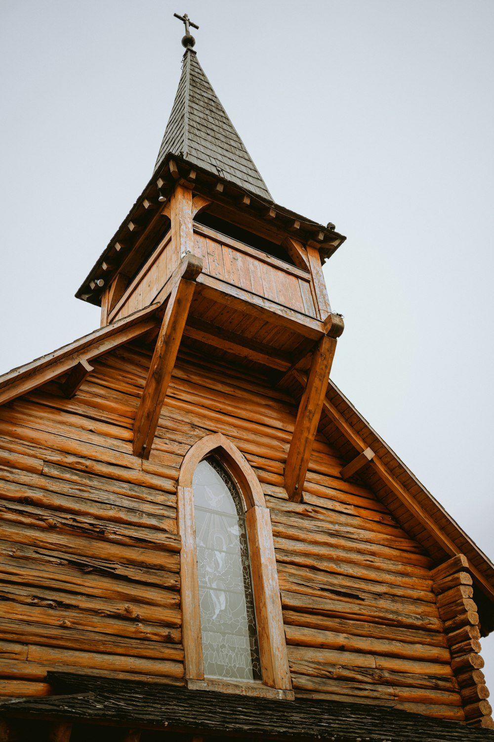 una iglesia de madera con un campanario y una cruz en la parte superior