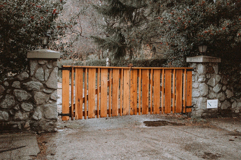 a wooden gate in front of a stone wall