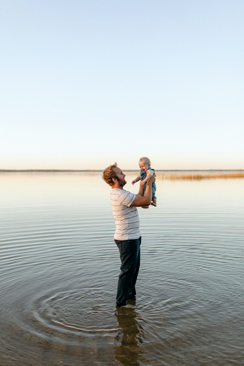 a man holding a baby in the water