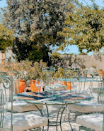 An outdoor patio set with elegant seating surrounded by lush greenery.