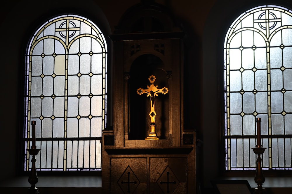 a cross in front of two stained glass windows