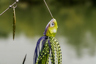 A close-up of a vibrant fishing lure glistening under sunlight on a wooden dock.