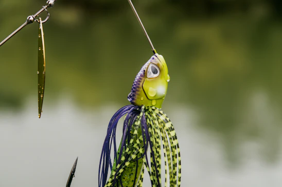 A close-up of a vibrant fishing lure glistening under sunlight on a wooden dock.