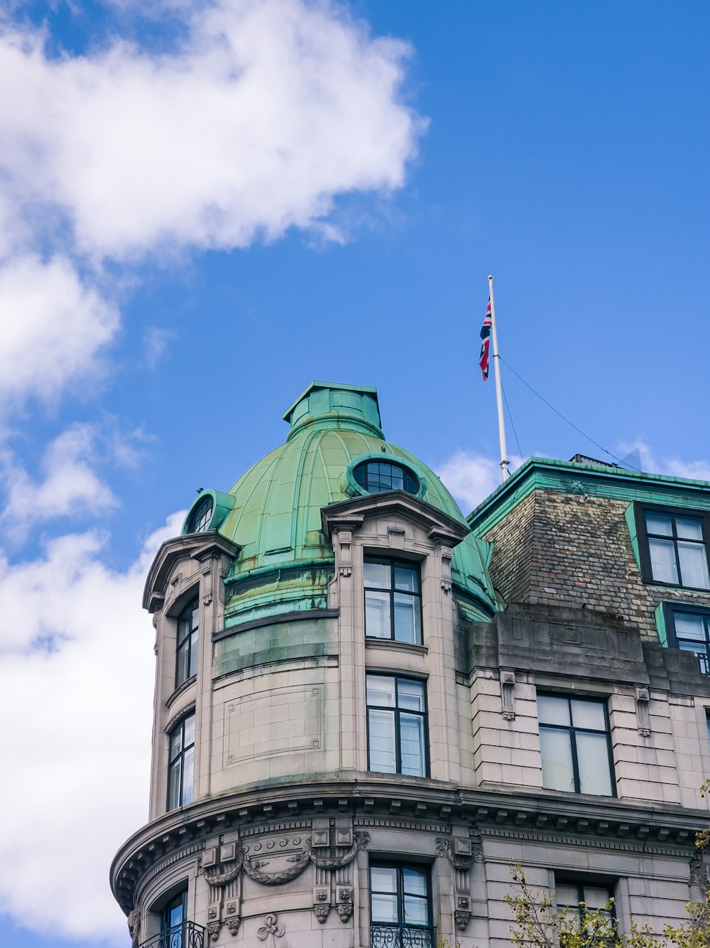 a building with a green roof and a flag on top