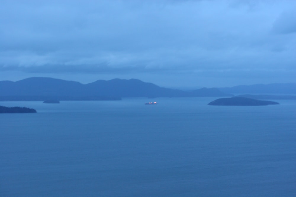 a large body of water with mountains in the background