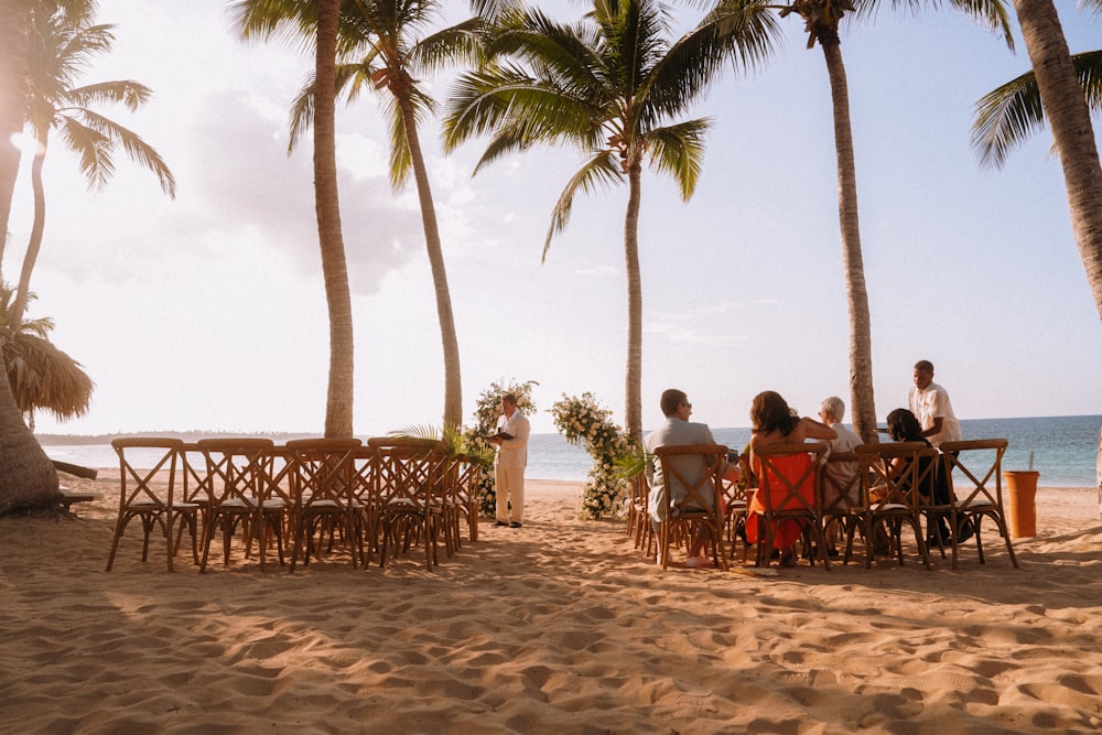 um grupo de pessoas sentadas em uma mesa em uma praia
