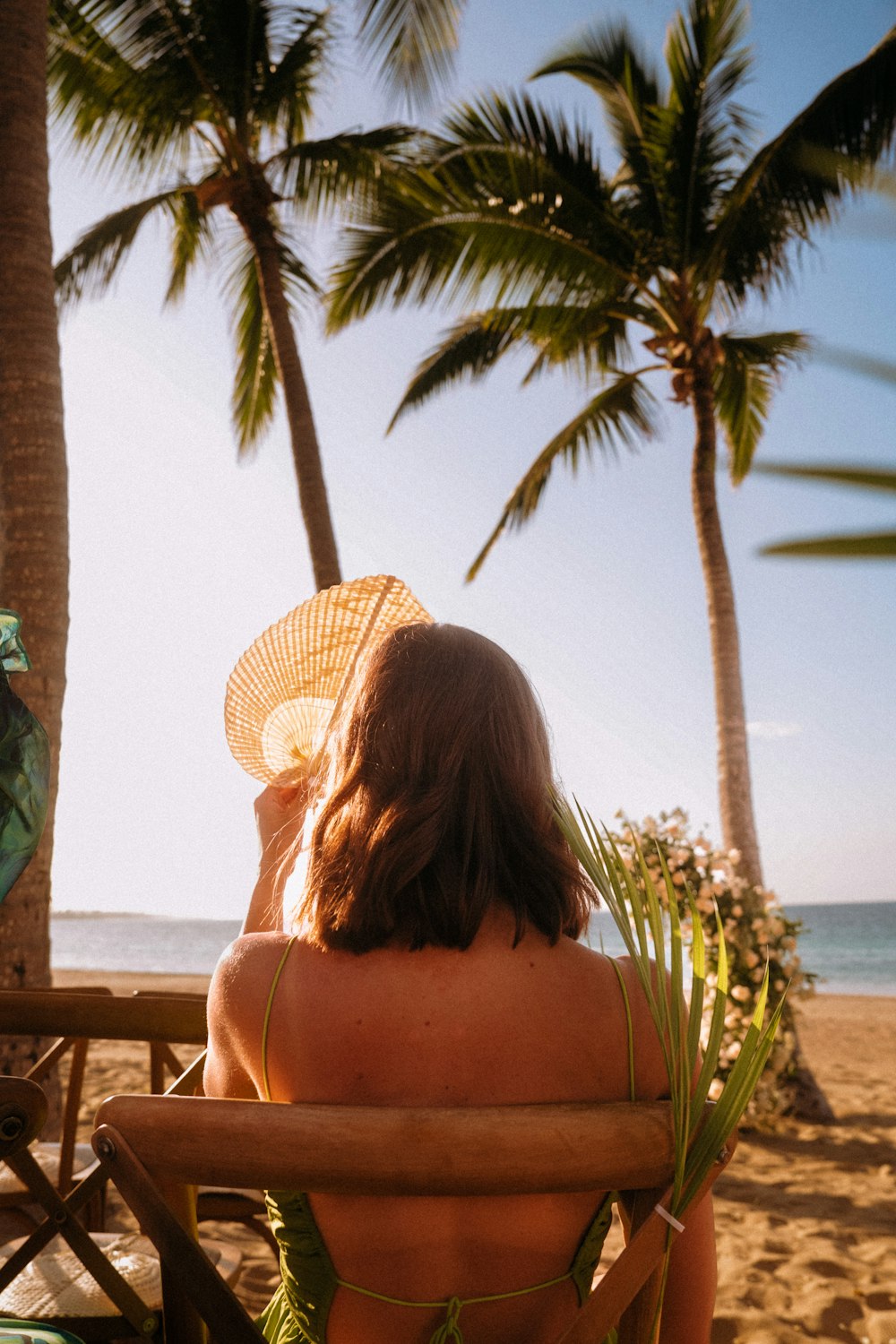 a woman sitting in a chair on the beach