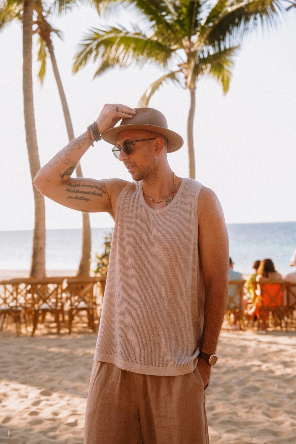 a man with a hat and sunglasses on a beach